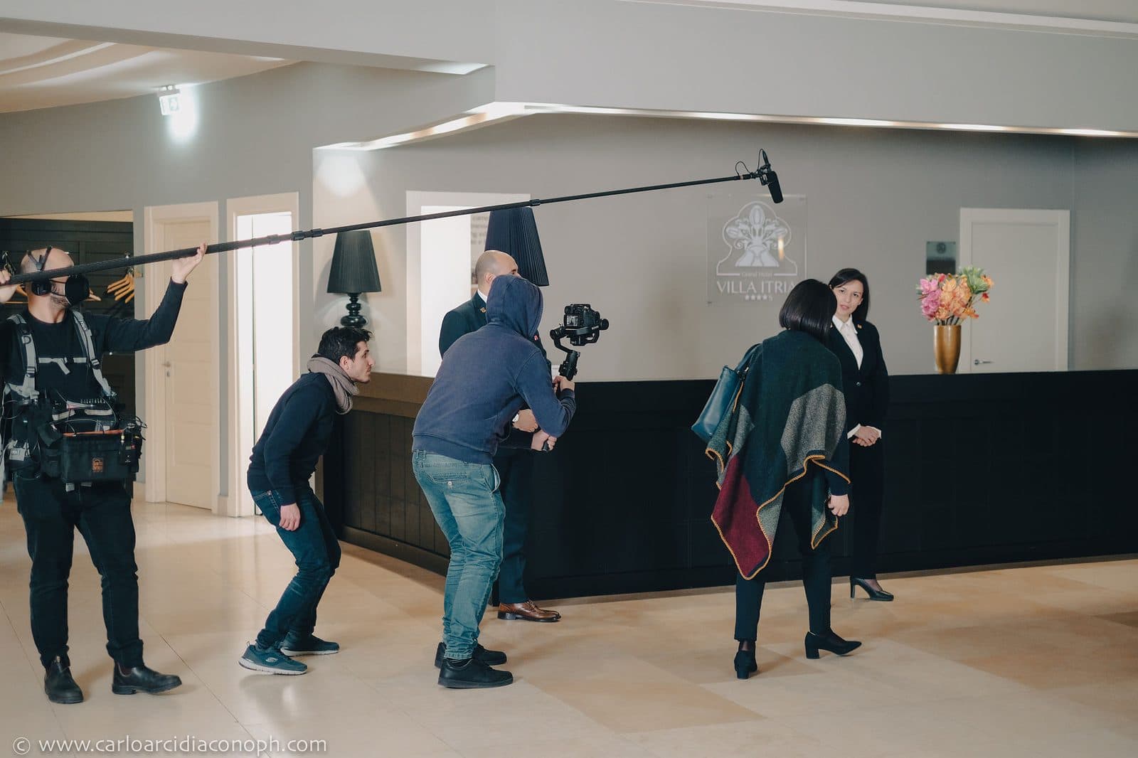 The crew filming a guest arriving at the concierge desk