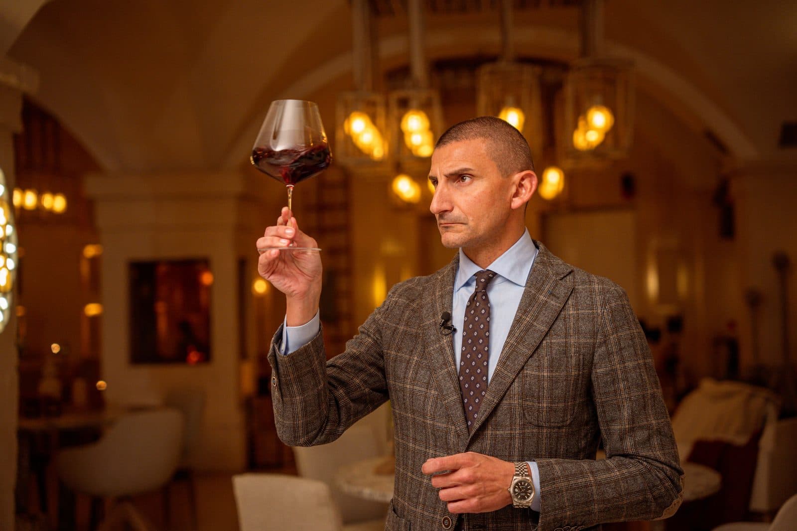 The presenter examining a glass of red wine