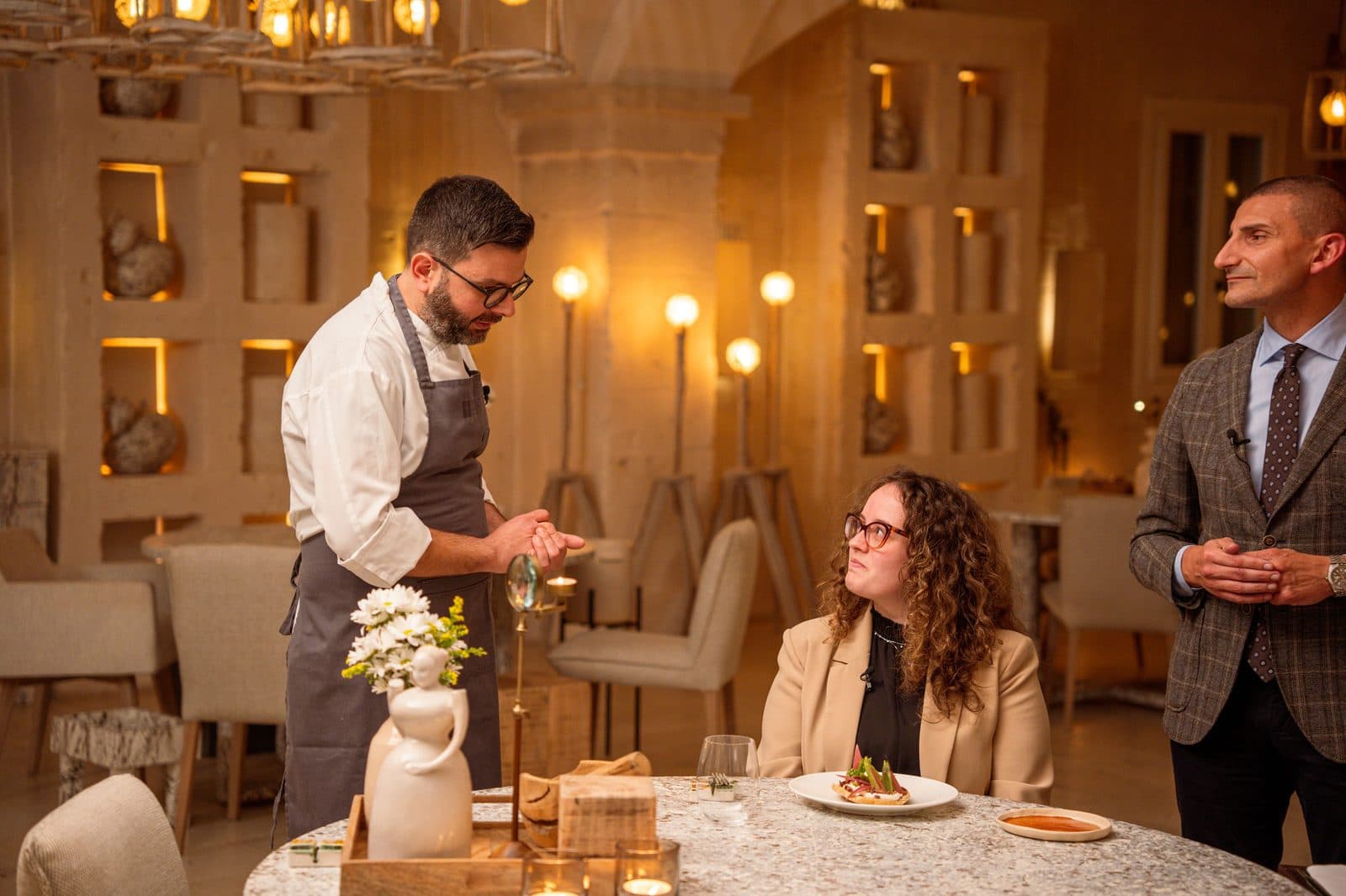 A dish being plated at the table during filming at Borgo Egnazia