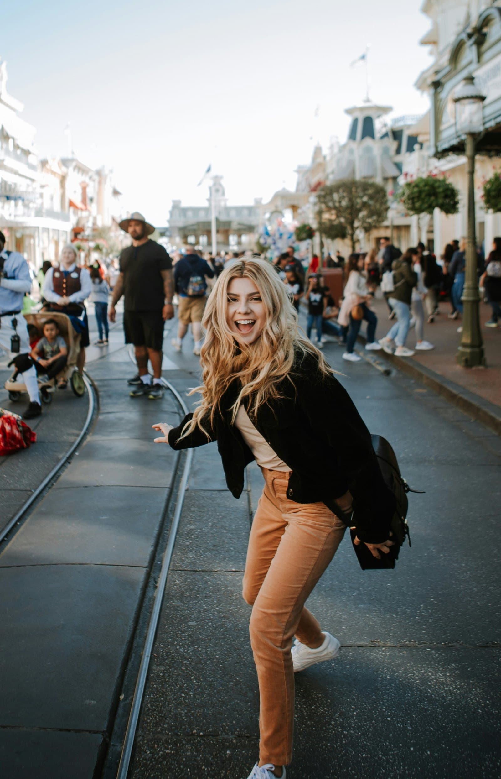 A young woman laughing in the street, the city behind her